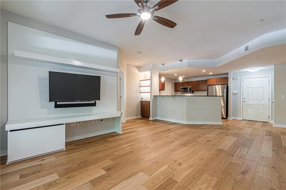 Unfurnished living room with ceiling fan and light