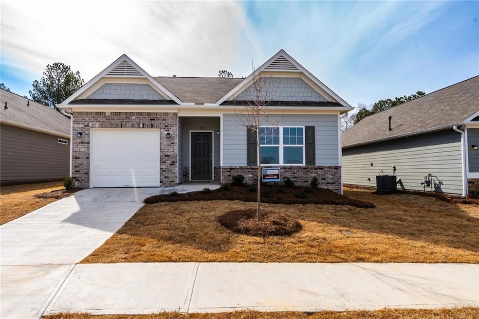 Craftsman-style home with brick siding, concrete driveway, central AC, and a garage