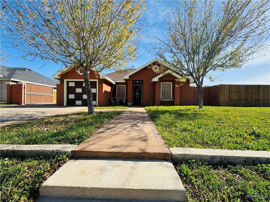 Ranch-style home featuring a garage and a front lawn