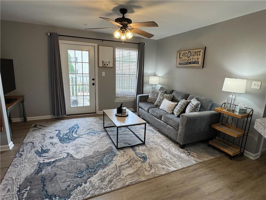 Living area with wood finished floors, baseboards, and ceiling fan