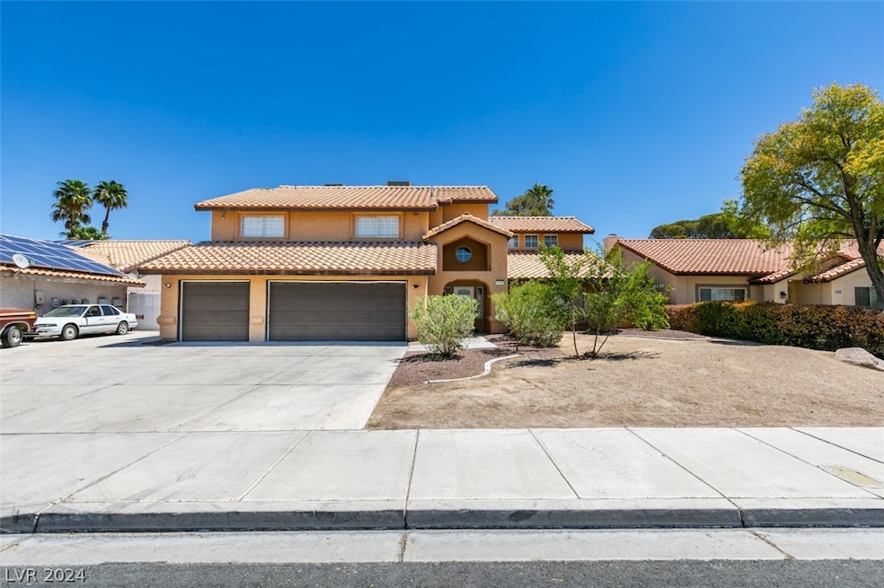 Front exterior with oversized driveway and possibl