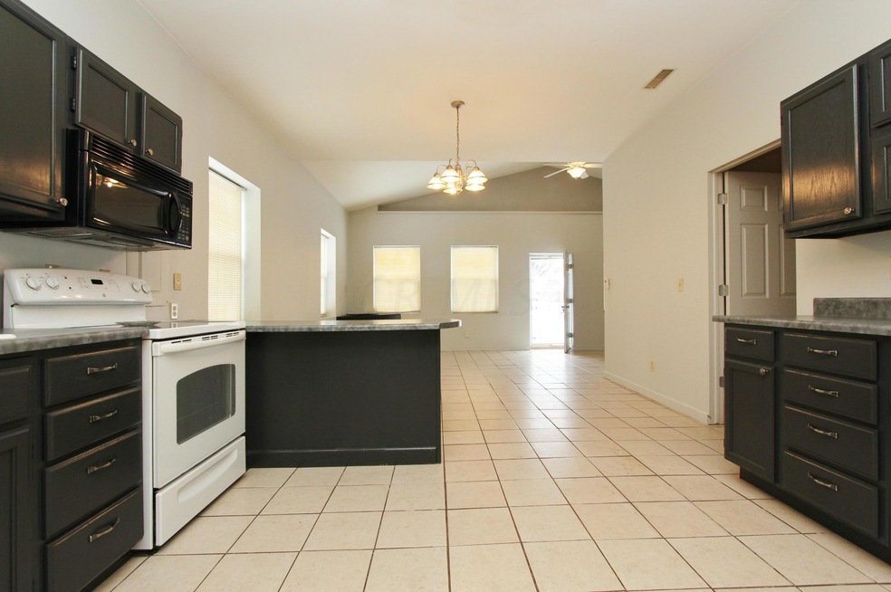 A view of the large kitchen w/ bar