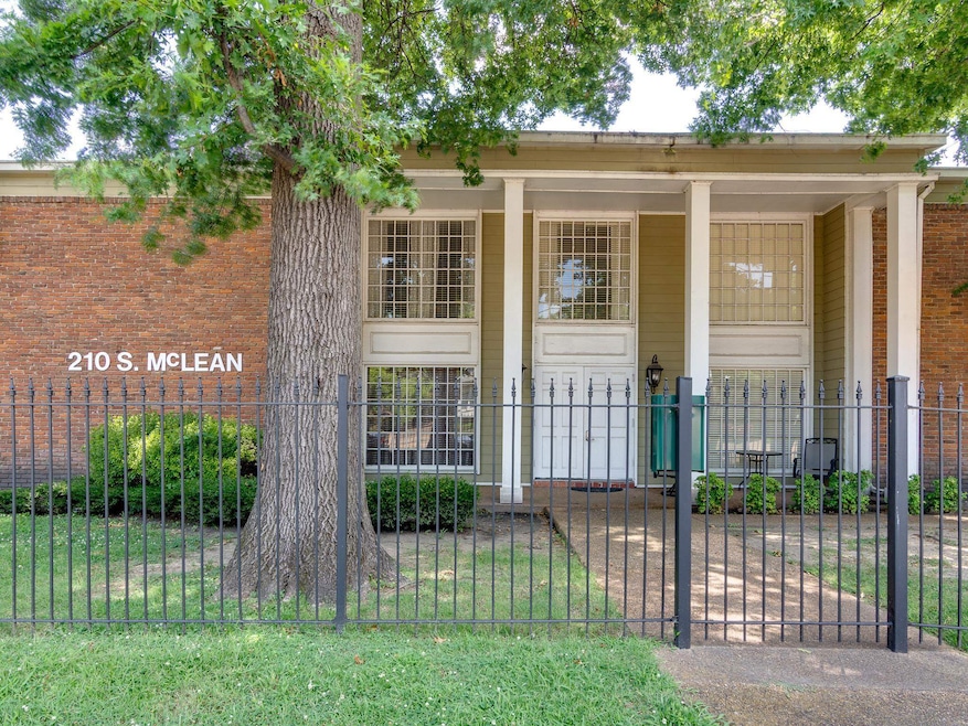 Nice green area with front porch and iron security fence around complete property.
