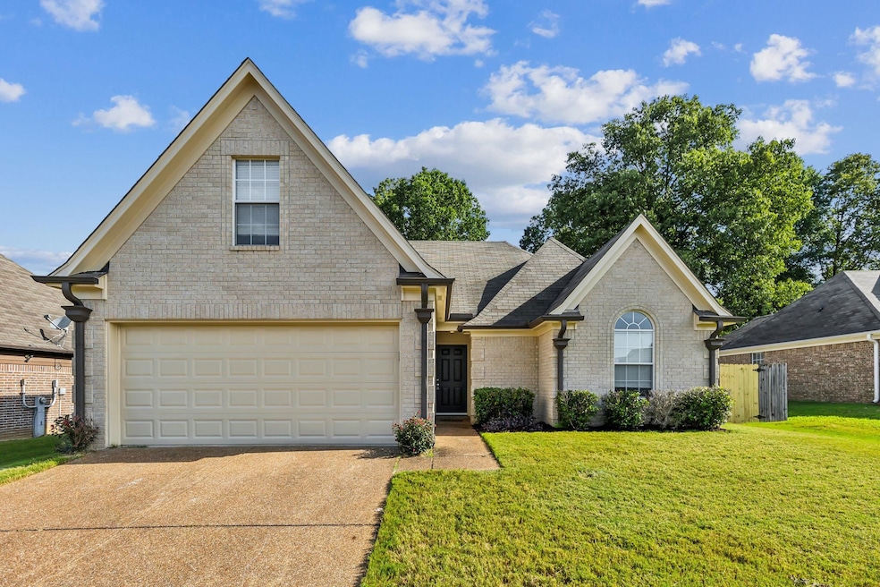 View of property featuring a garage and a front ya