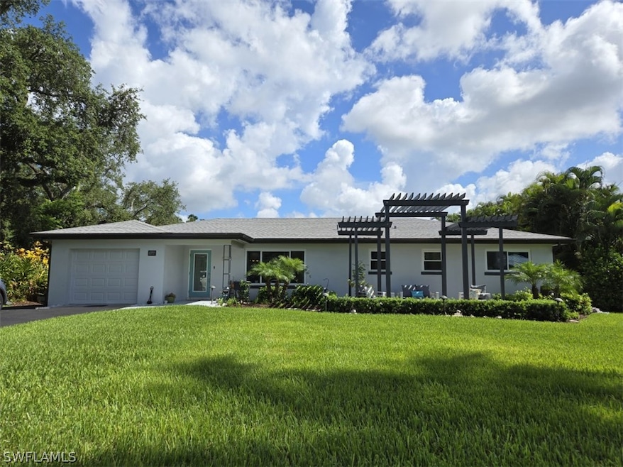 Single story home with a garage, a front lawn, and