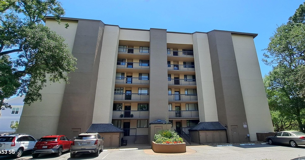 View of apartment building / complex featuring uncovered parking
