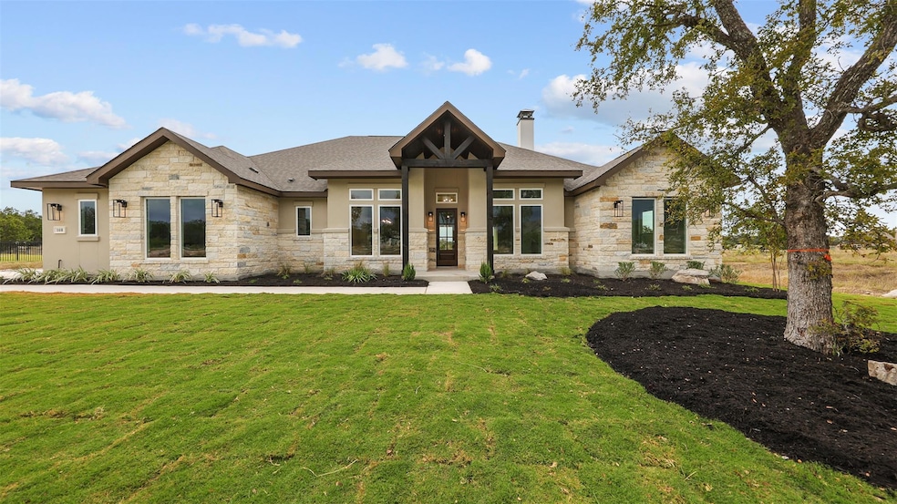 View of front of home featuring stone siding, a f