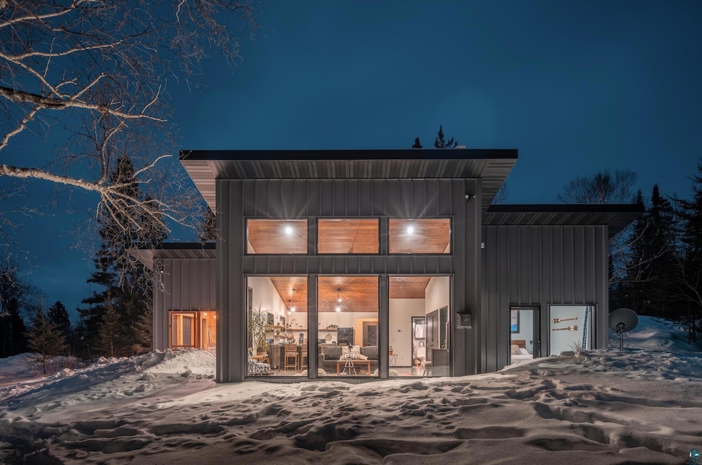 Snow covered back of property with a garage