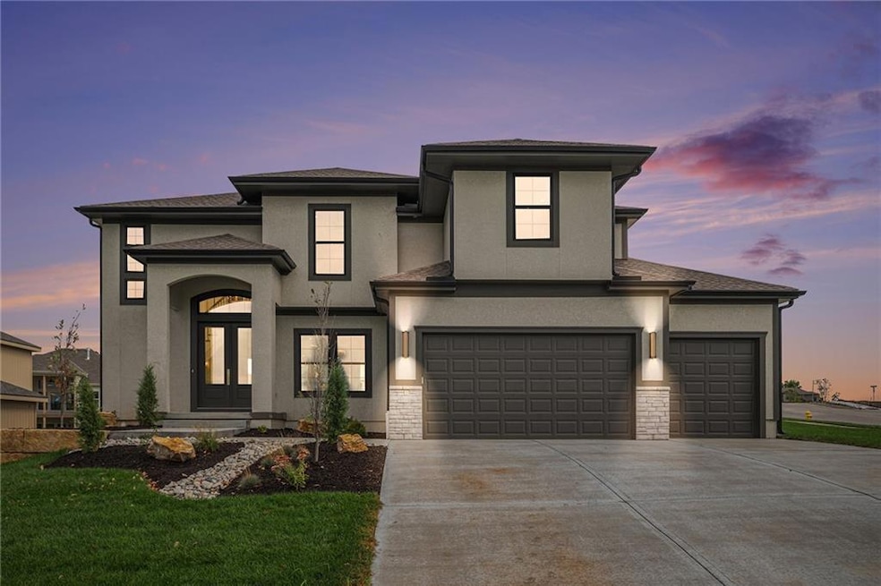 Prairie-style house featuring stucco siding, concrete driveway, roof with shingles, and stone siding