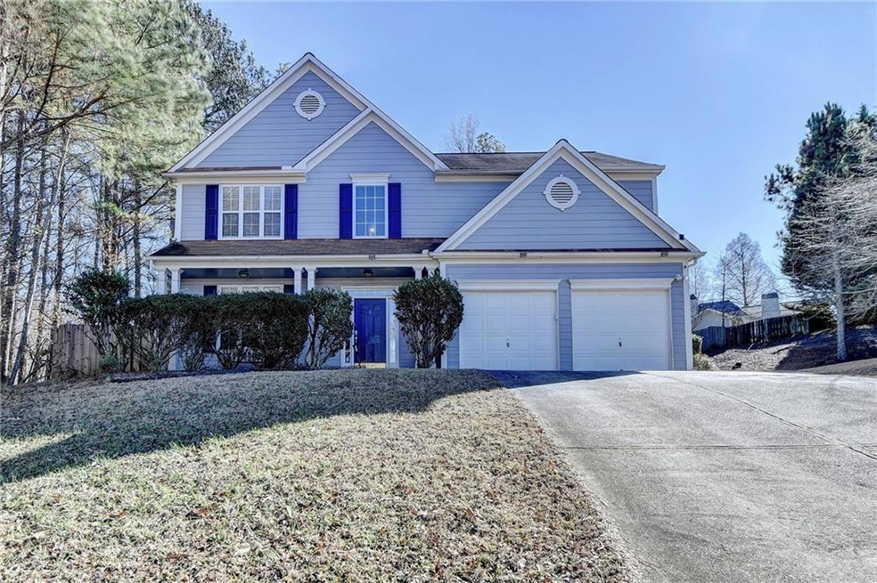 View of property featuring a front lawn and a gara