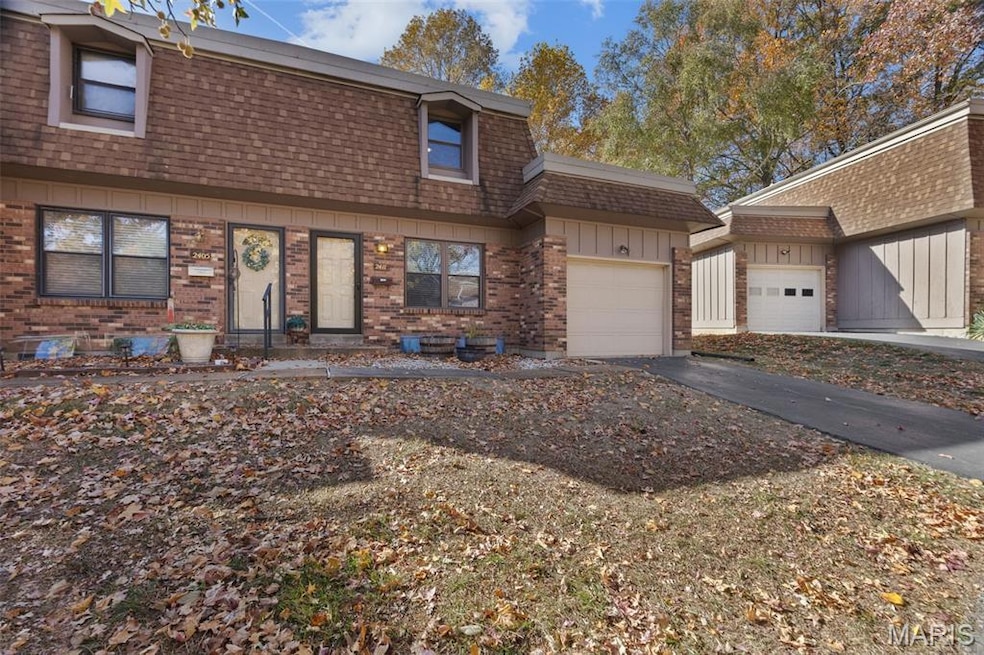 View of front facade featuring a garage, a shingled roof, board and batten siding, mansard roof, and driveway