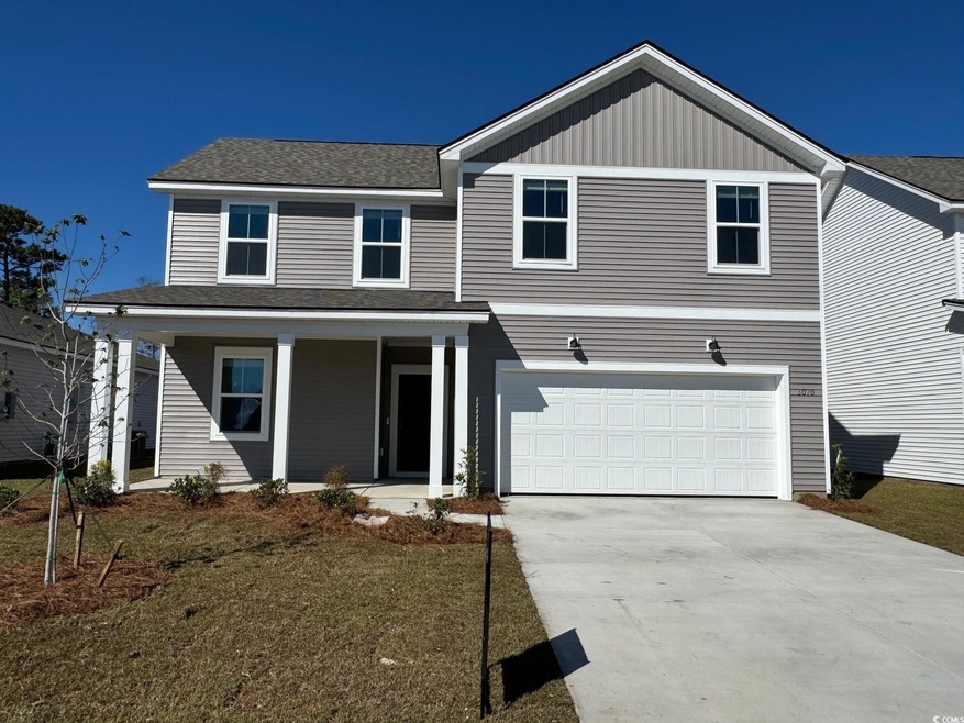 View of front facade with covered porch, concrete driveway, board and batten siding, an attached garage, and roof with shingles