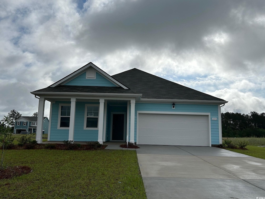 Single story home with a garage, driveway, a front yard, and a porch