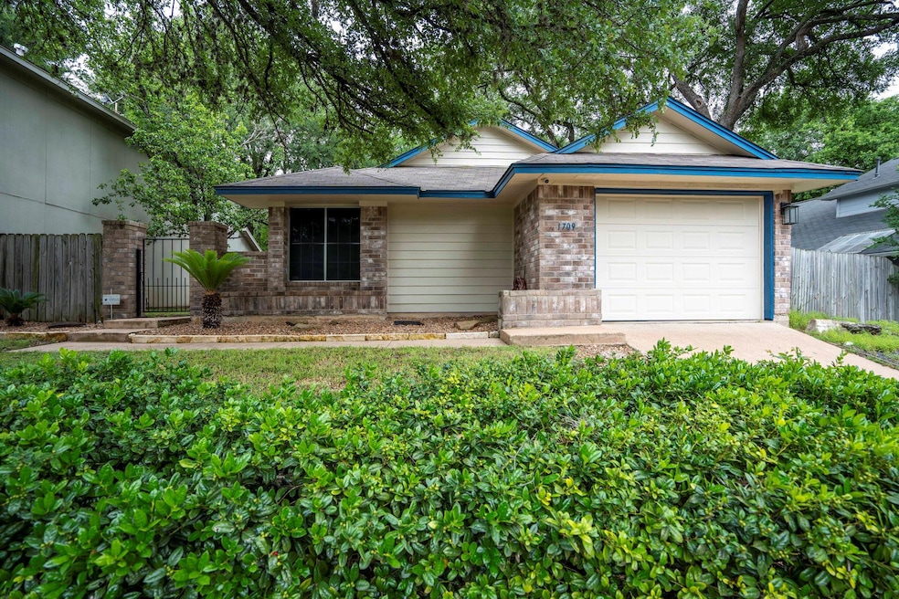 Ranch-style house featuring a garage and driveway