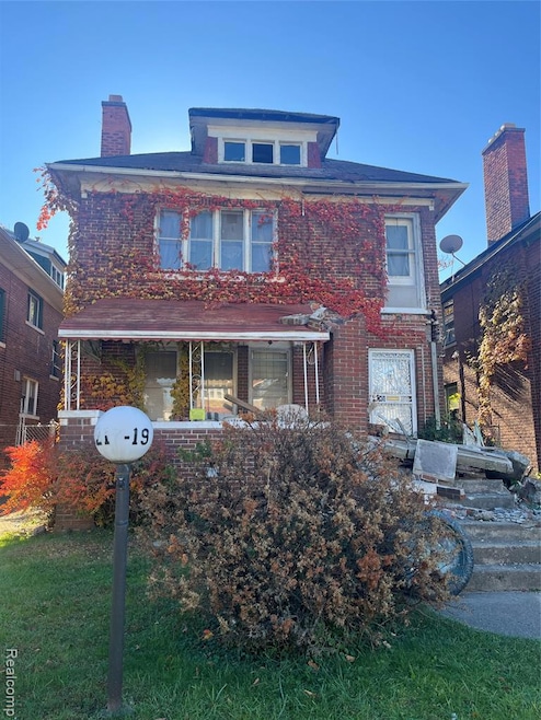 American foursquare style home featuring brick siding and a chimney