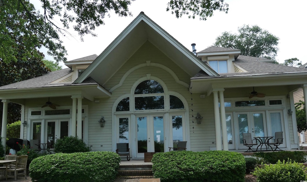 Property entrance featuring french doors, ceiling fan, and roof with shingles