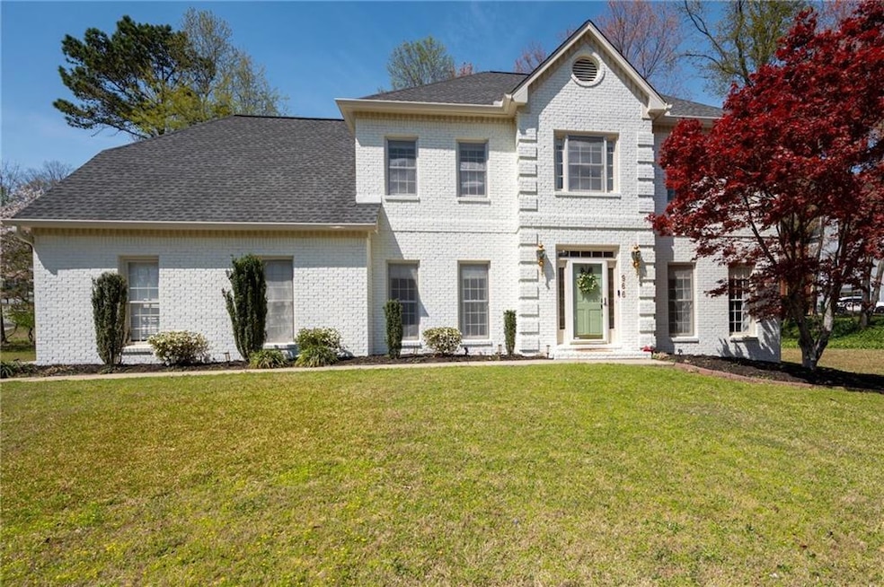 Colonial home featuring brick siding, a shingled r