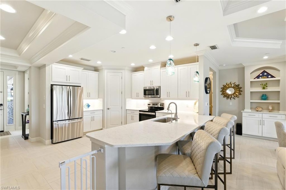 Kitchen featuring crown molding, stainless steel appliances, a breakfast bar, a sink, and visible vents