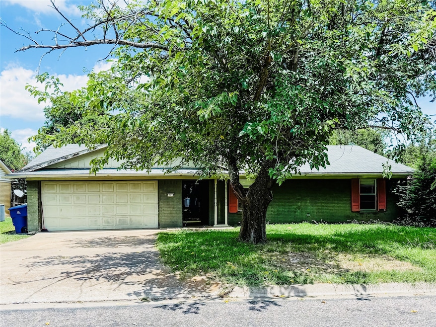 View of front facade featuring an attached garage, driveway, and brick siding
