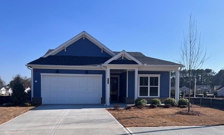 View of front of property featuring a garage and concrete driveway