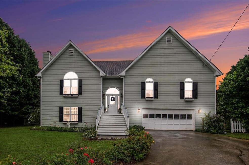 View of front of property with asphalt driveway, a garage, a front lawn, and a chimney