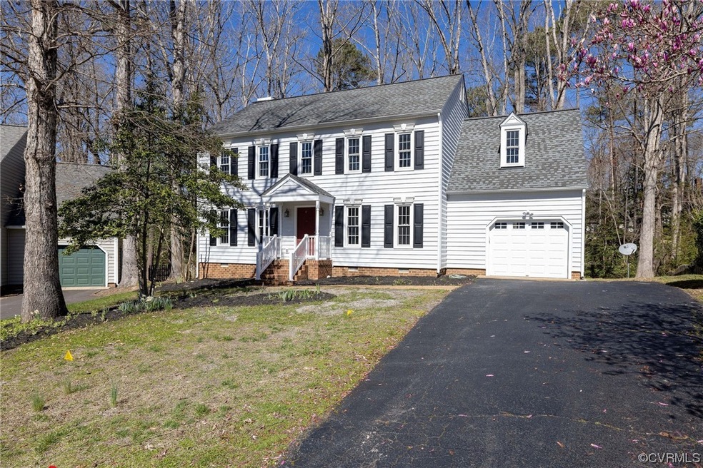 Colonial inspired home featuring a garage and a fr