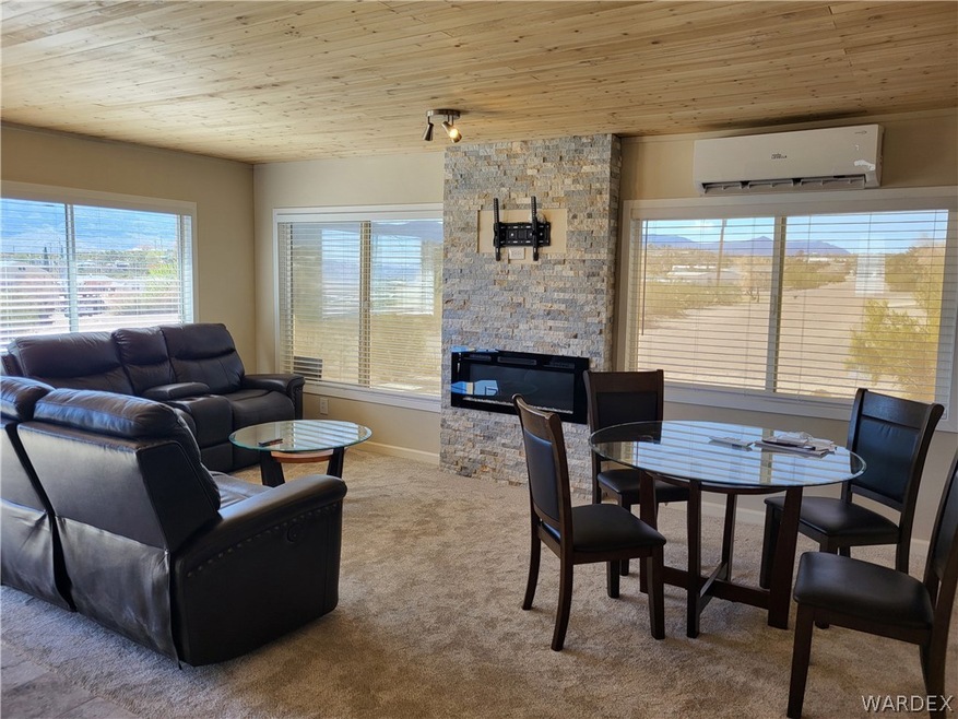 Living room with wooden ceiling, a wall mounted AC