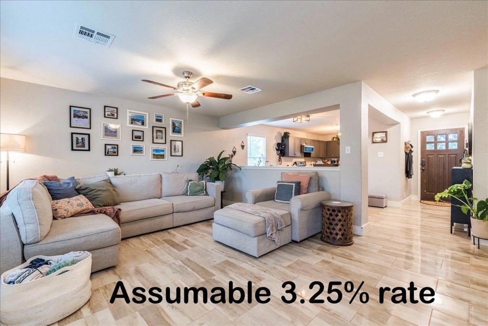 Living room with a ceiling fan, visible vents, an