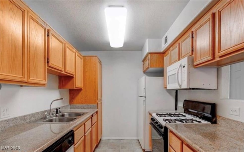 Kitchen featuring gas stove, white microwave, ligh