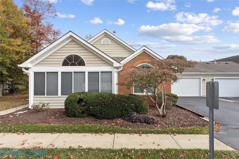 Ranch-style house with asphalt driveway, brick siding, and a garage