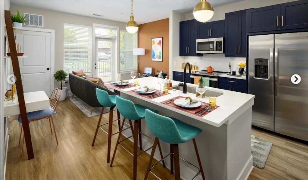 Kitchen featuring an island with sink, stainless s