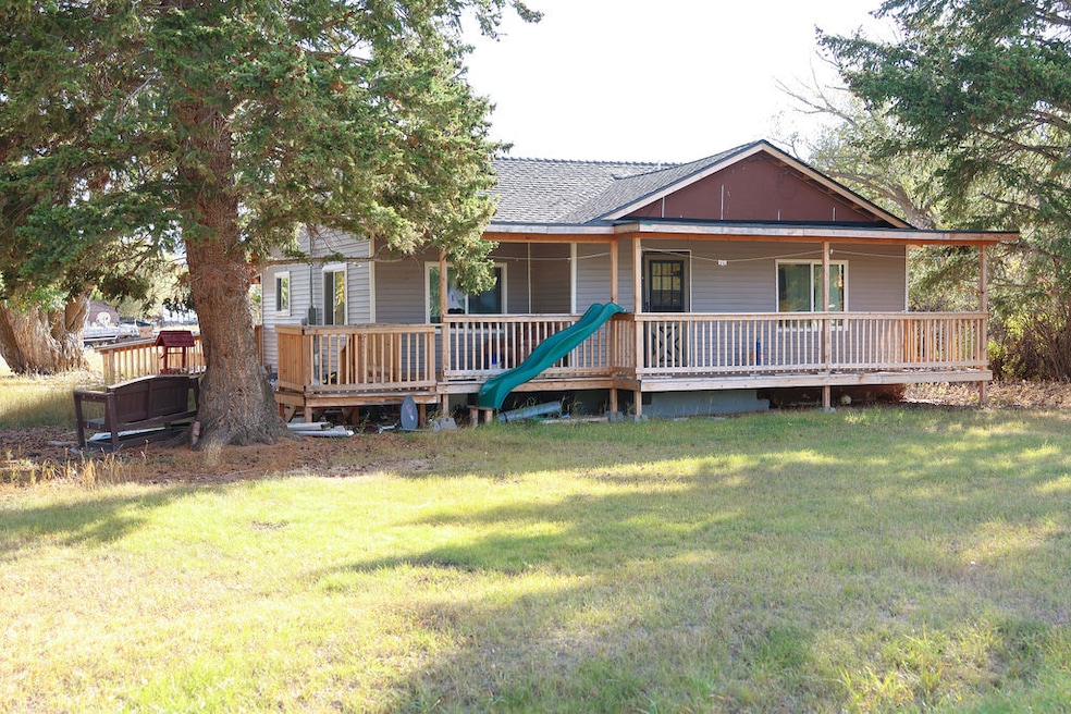 View of front of house with a front yard, covered porch, and a shingled roof