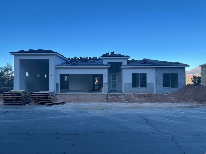 View of front of house featuring stucco siding, a tiled roof, and a patio