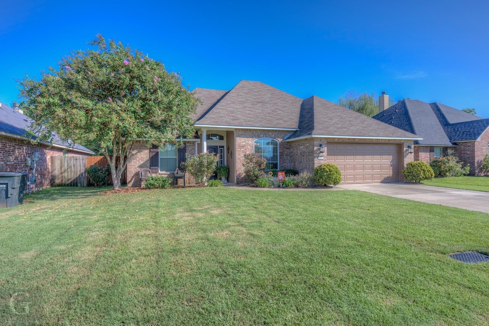 Single story home with a garage and a front lawn
