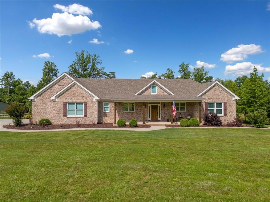 Ranch-style home featuring brick siding, a front lawn, and a porch