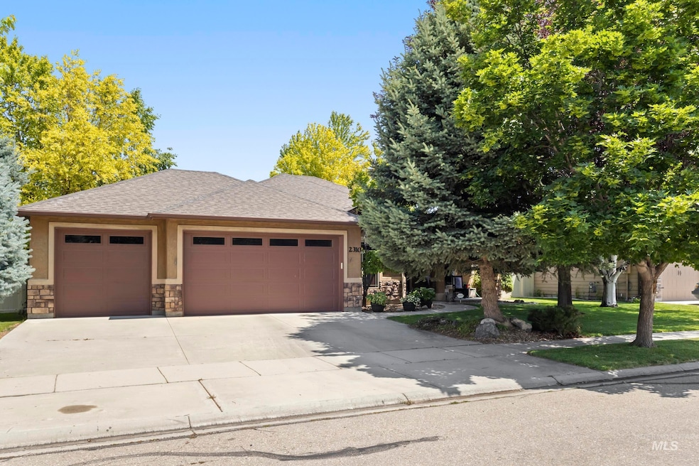 View of front facade featuring concrete driveway, an attached garage, stone siding, a shingled roof, and stucco siding