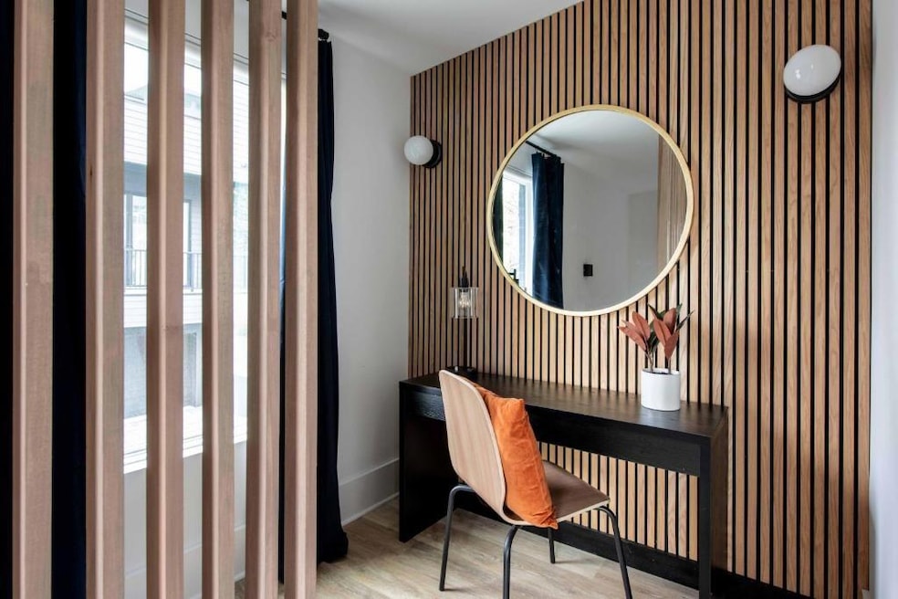 Office with wallpapered walls, healthy amount of natural light, wood finished floors, and baseboards