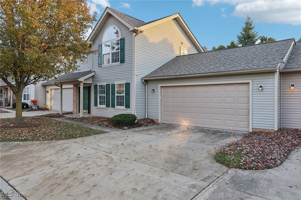 Traditional-style house featuring concrete driveway, roof with shingles, and a garage