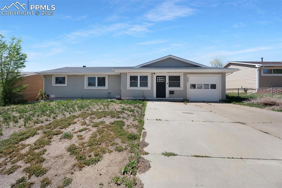 Ranch-style house with a garage, fence, stucco sid