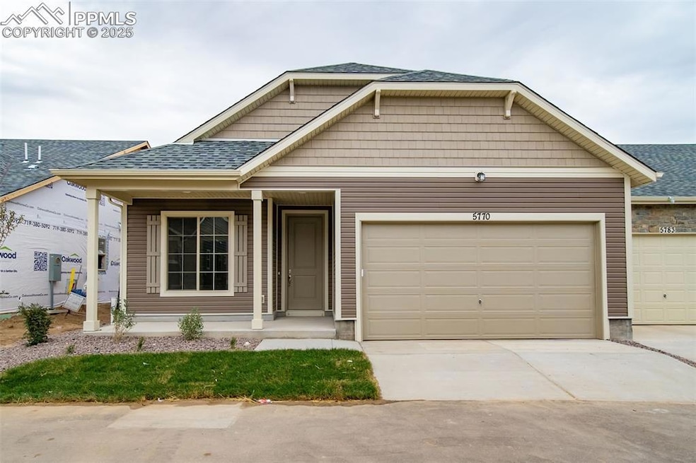 View of front facade featuring concrete driveway, a shingled roof, covered porch, and a garage