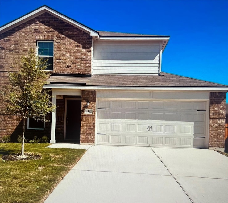 View of front facade with driveway, brick siding,