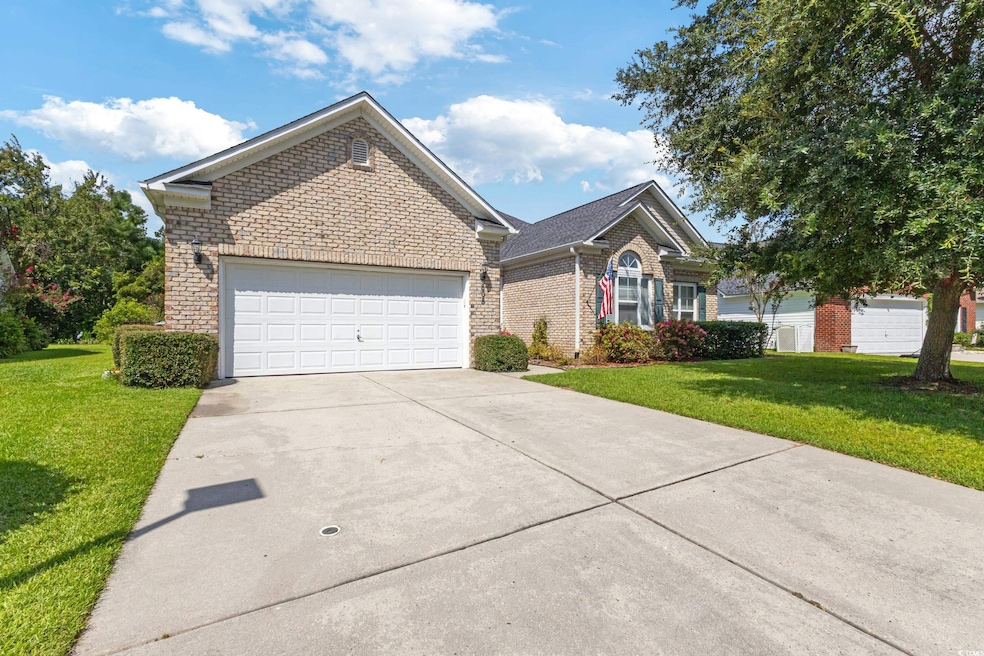 Single story home with brick siding, a front lawn, driveway, and an attached garage