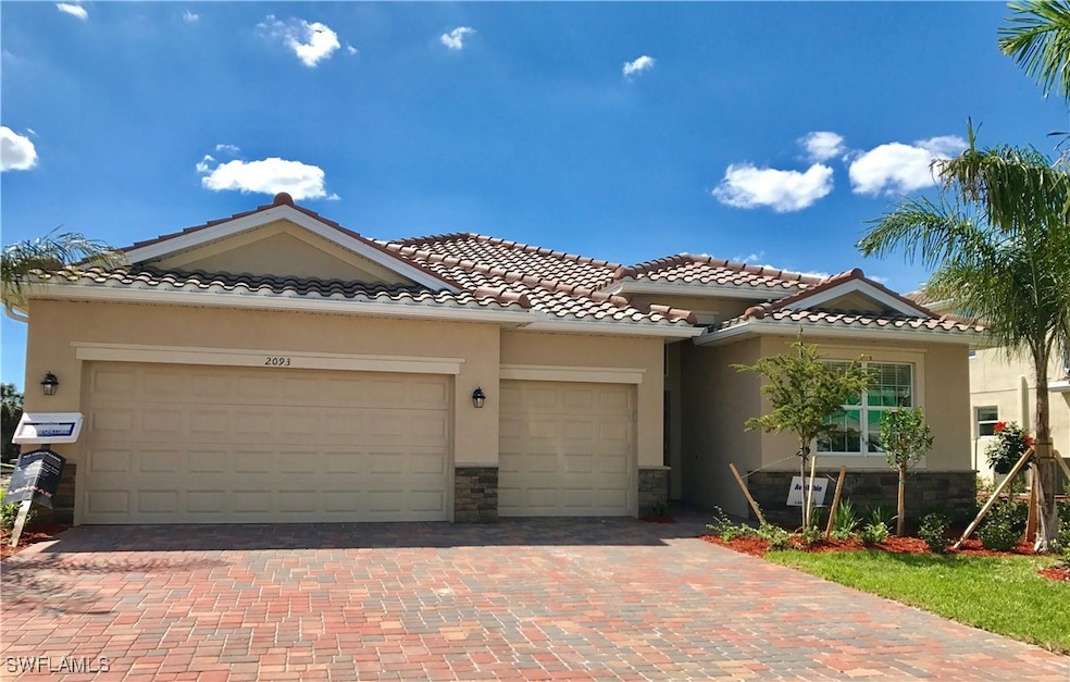 Mediterranean / spanish-style home with stone siding, an attached garage, stucco siding, decorative driveway, and a tiled roof