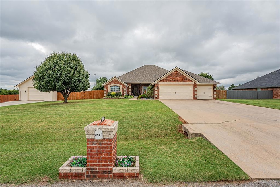 View of front facade featuring roof with shingles, driveway, brick siding, and a garage