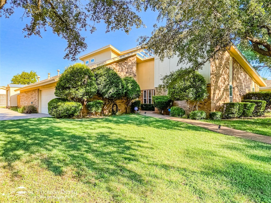 Mid-century home with a front lawn, stucco siding,