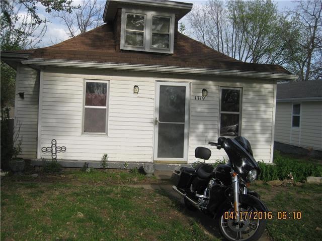 Front view with enclosed porch, flowers coming up!