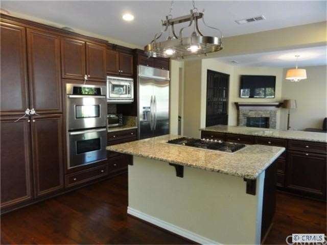 Kitchen with dark rich cabinetry, granite counter 