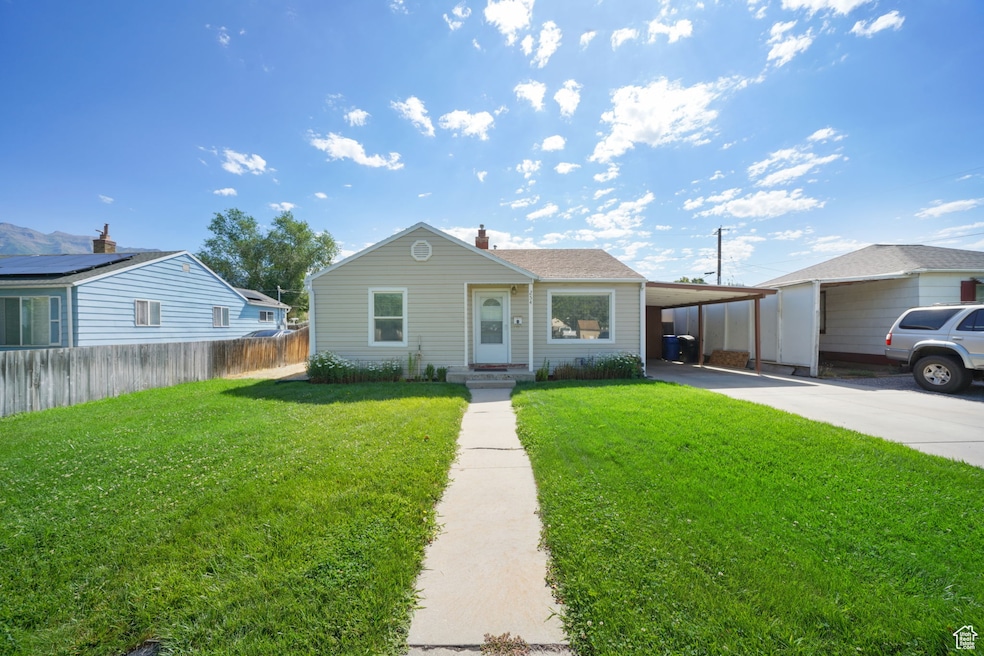 View of front of home featuring a carport, driveway, and a chimney