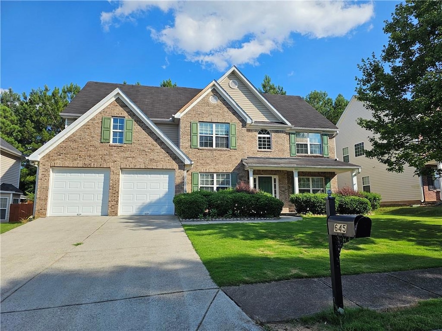 View of front of home with concrete driveway, brick siding, and a front lawn