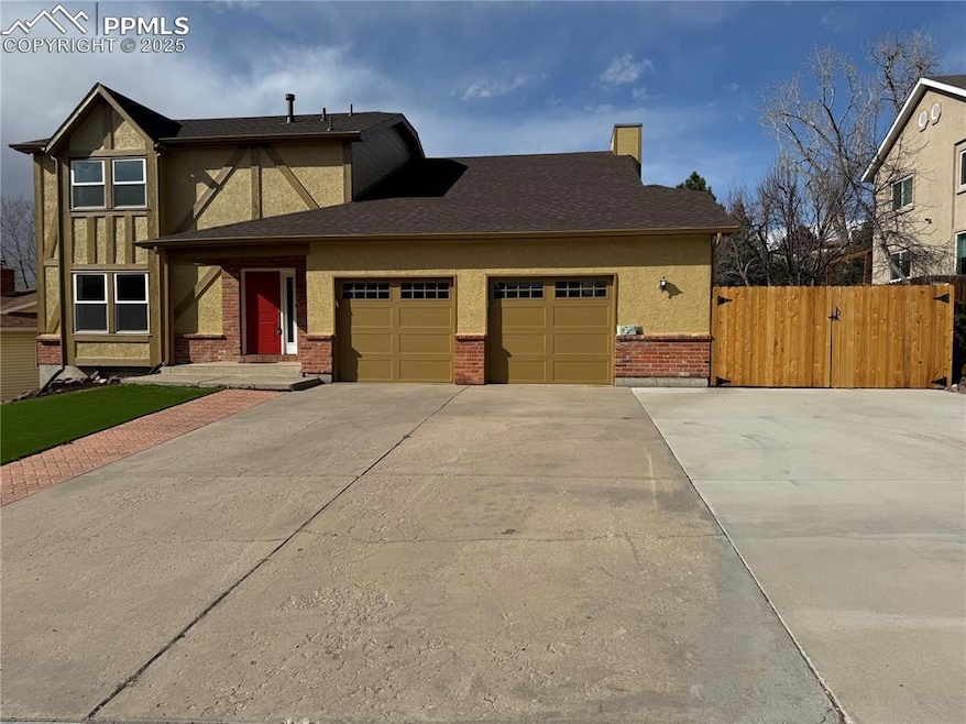 View of front of house featuring fence, an attache